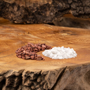 Eine Mischung aus rötlich-braunem Goldfluss und weißem Milchopal, als kleine Steinchen auf einer rustikalen Holzoberfläche arrangiert.