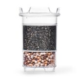 Eine transparente Wasserfilter-Kartusche, die im oberen Bereich mit Aktivkohle und im unteren Bereich mit Mineralkugeln gefüllt ist.