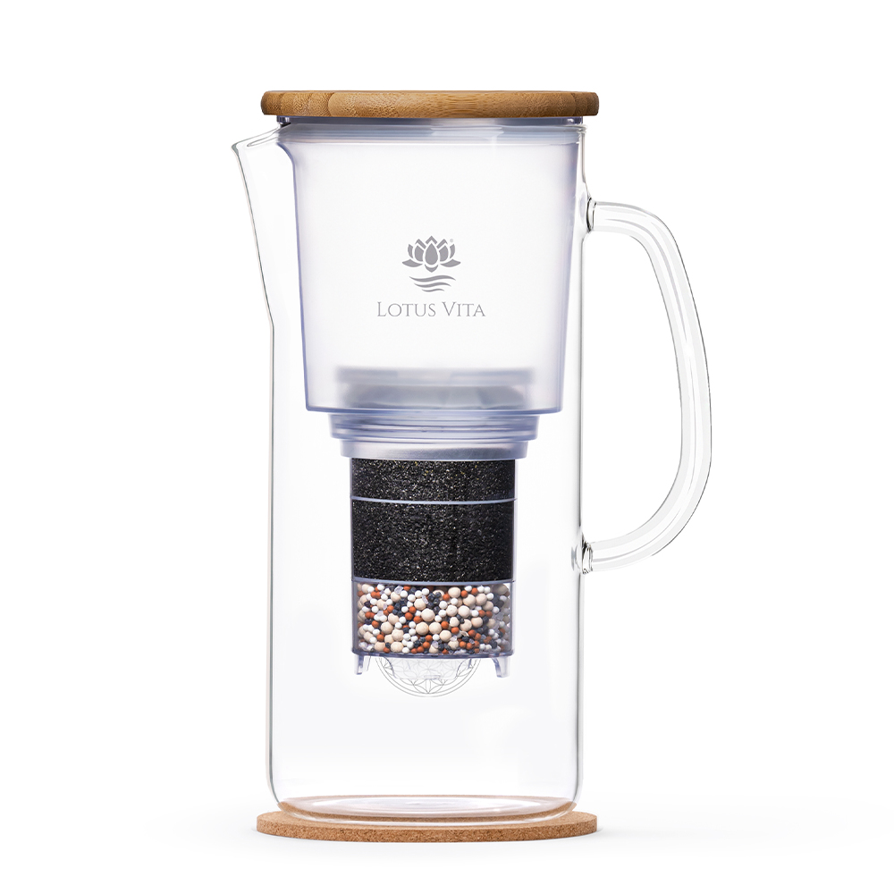 Eine elegante Glas-Filterkaraffe von Lotus Vita mit Bambusdeckel und Kork-Untersetzer, deren mehrstufiger Wasserfilter im Inneren sichtbar ist.